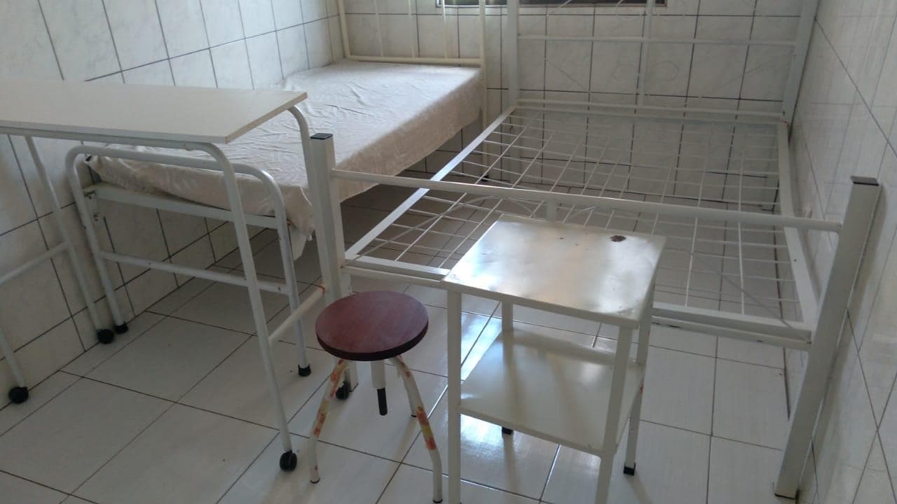 Cama hospitalar, mesa do leito, estante, base metálica e banquinho.  ·