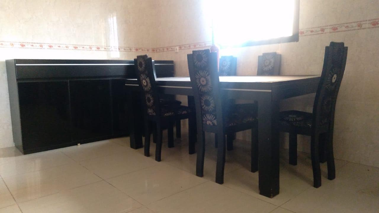 Mesa, armário, vaso decorativo e cadeiras. ·