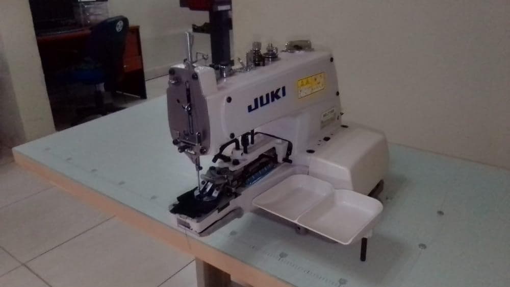 Máquina de cozer botão ·